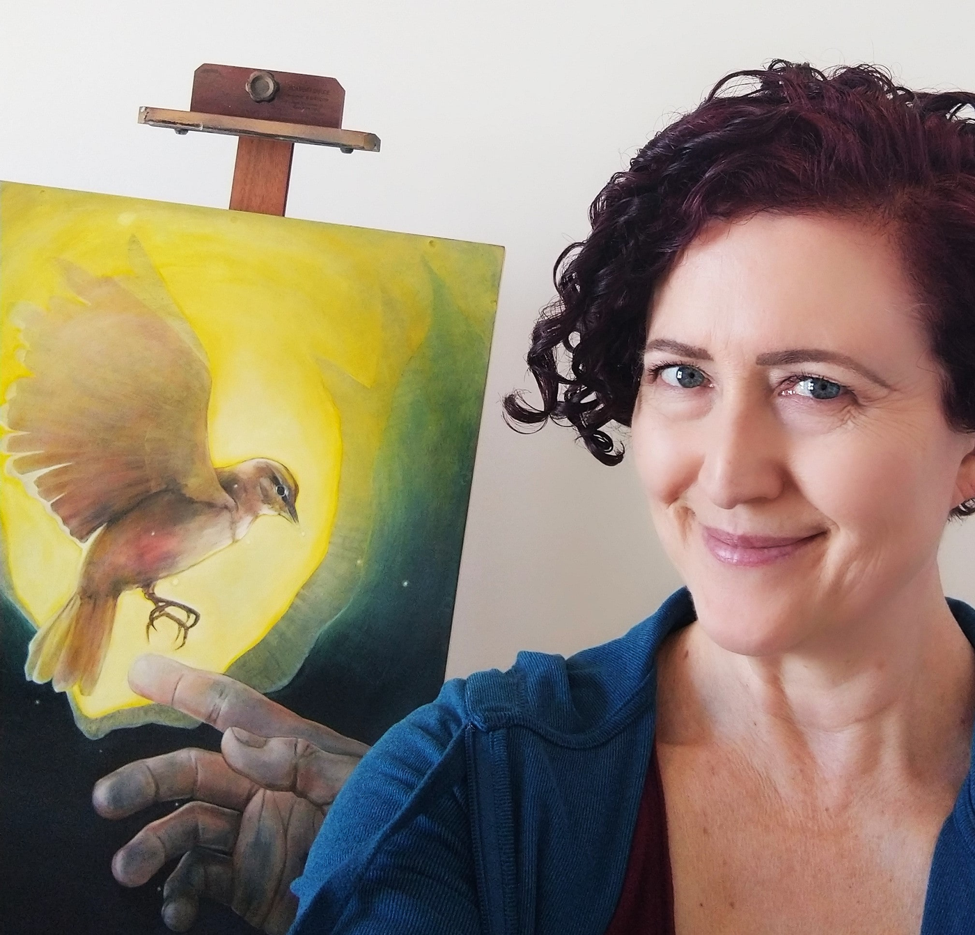 Carin Fausett holding one of her paintings.